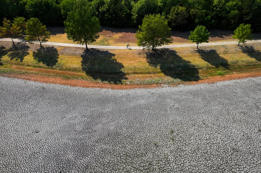 A cyclist rides around the dry bed of a pond in the Fred E. Harris Section of the Spring...