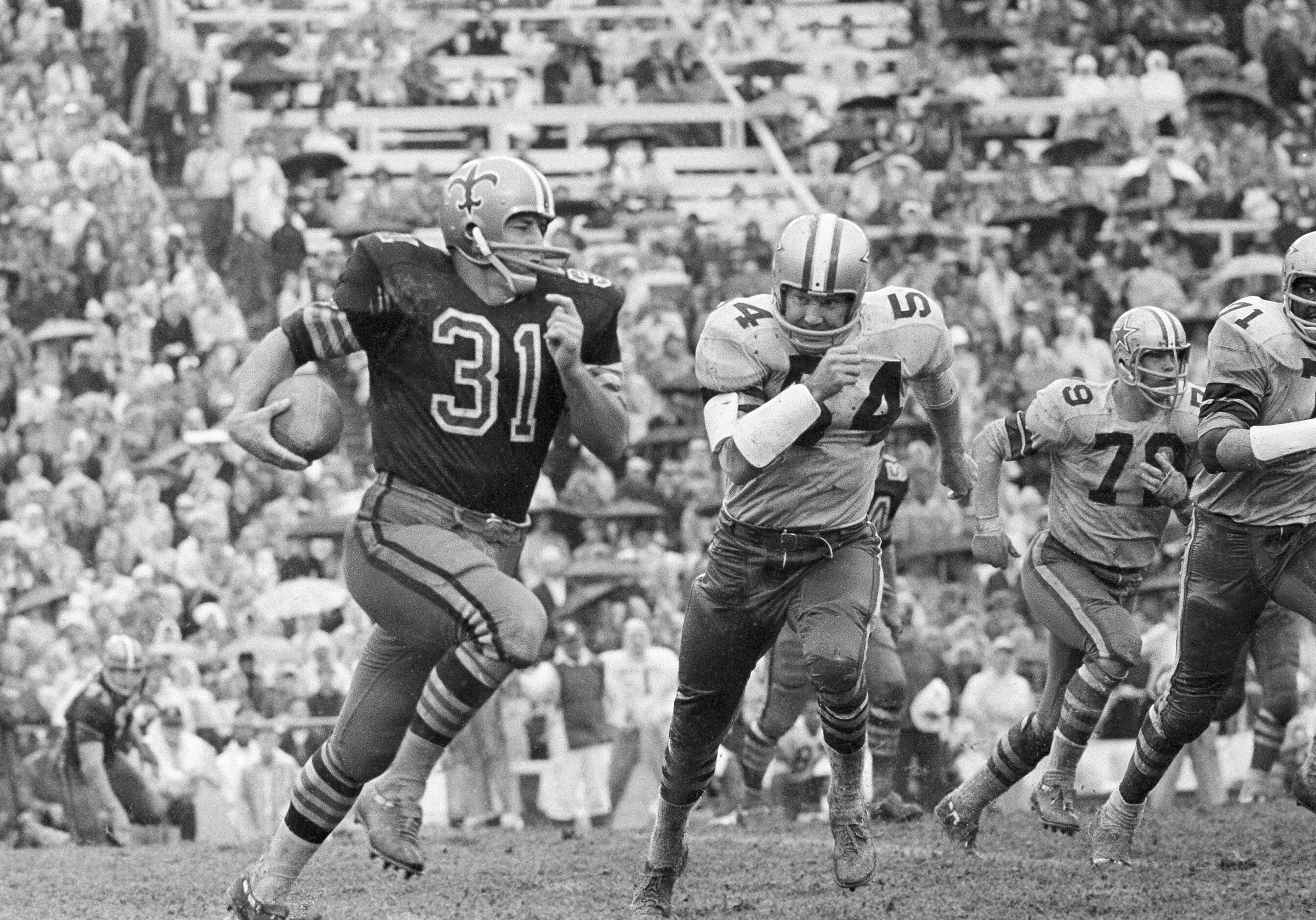 FILE - New Orleans Saints' Jim Taylor (31) runs for a first down as Dallas Cowboys' Chuck...