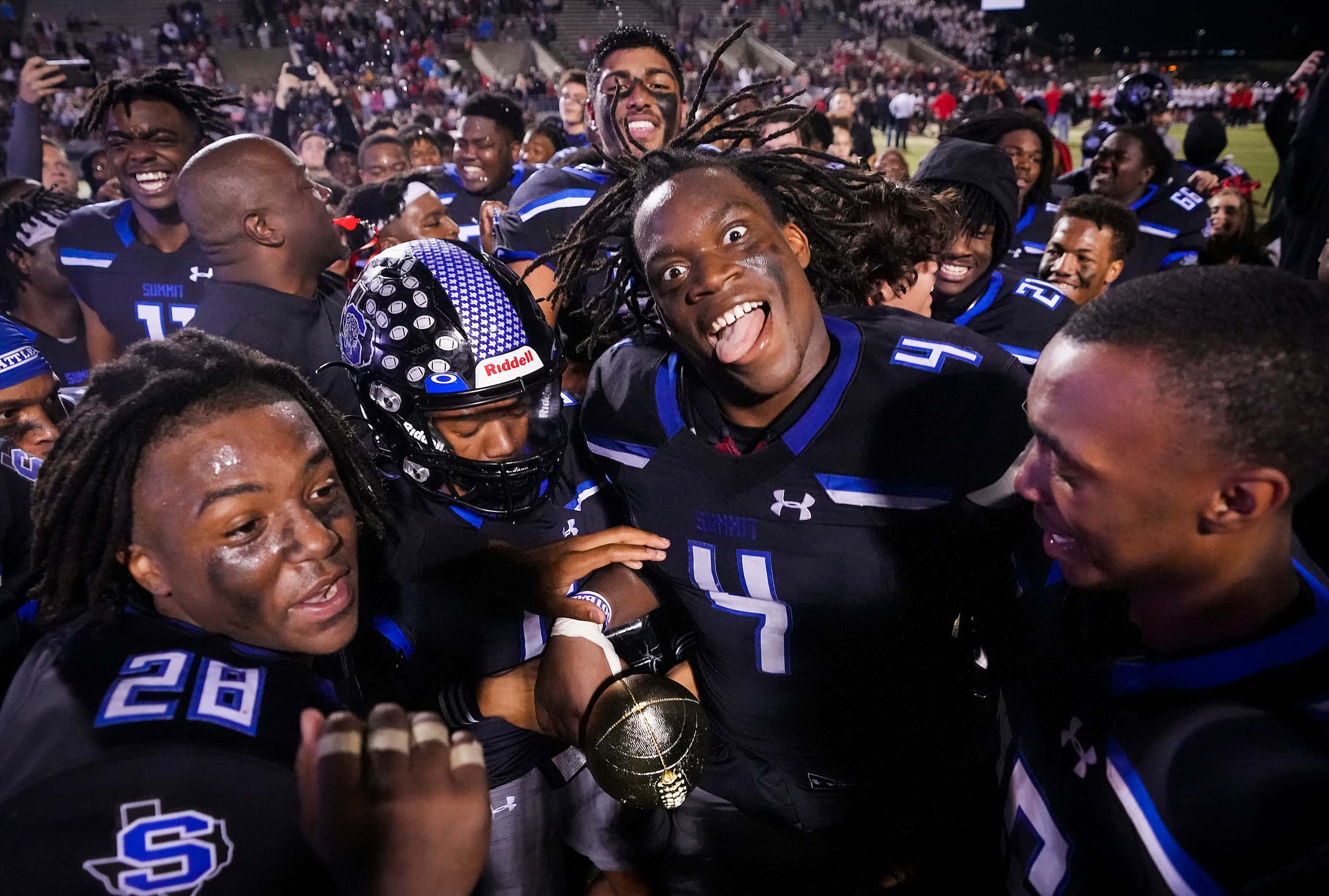Mansfield Summit defensive lineman Joseph Adedire (4) celebrates with the game trophy after...