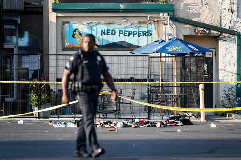 Shoes are piled outside the scene of a mass shooting including Ned Peppers bar, Sunday, Aug....