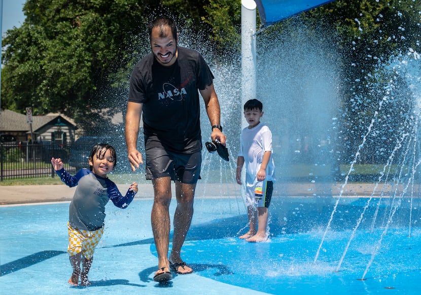 Mateo Perez, 2, and his dad, Matiaz Perez, soaked in the sun and water on the spray pad at...