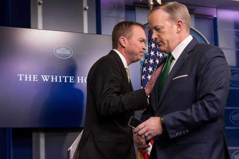 White House press secretary Sean Spicer, right, give the podium to Budget Director Mick...