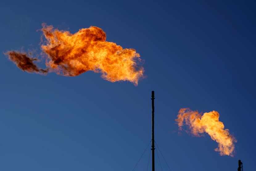 Flares burn off methane and other hydrocarbons at an oil and gas facility in Lenorah, Texas,...