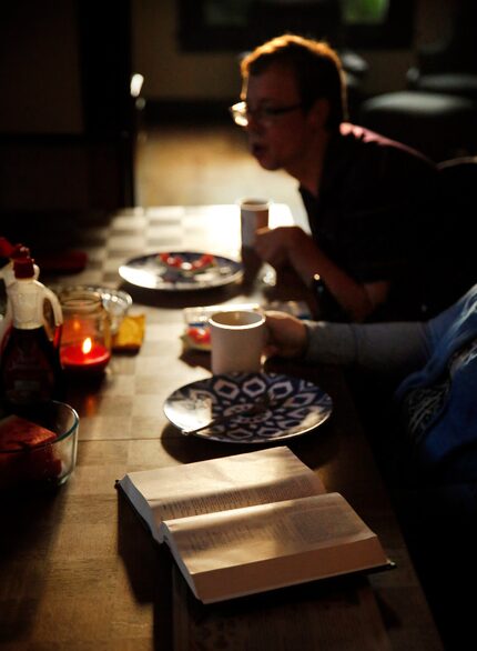 Residents and a visitor to the Cochran House read from the Bible over breakfast. (Tom...