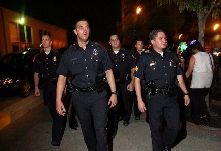 Dallas officers walk the streets of Deep Ellum on August 23, 2003 after Mayor Laura Miller...