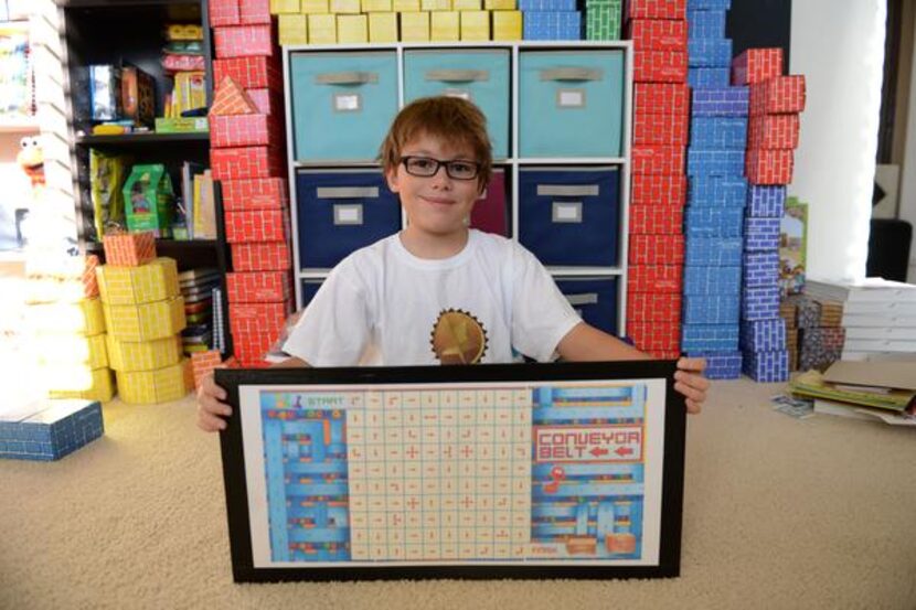 
Franklin points out features of the board game he created, Conveyor Belt, which he shows...