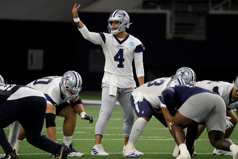Dallas Cowboys quarterback Dak Prescott (4) signals at the line of scrimmage as the team...