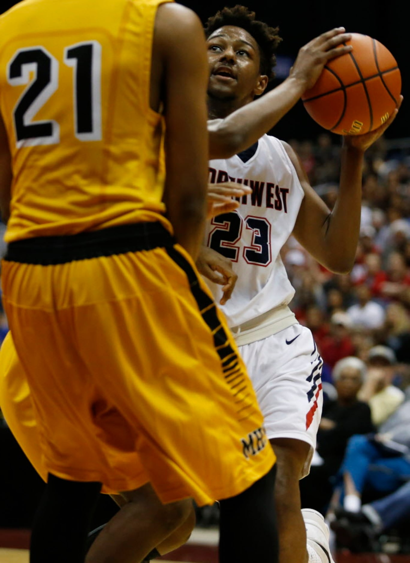 Justin Northwest's Julian Smith (23) drives to the basket through Fort Bend Marshall's Floyd...