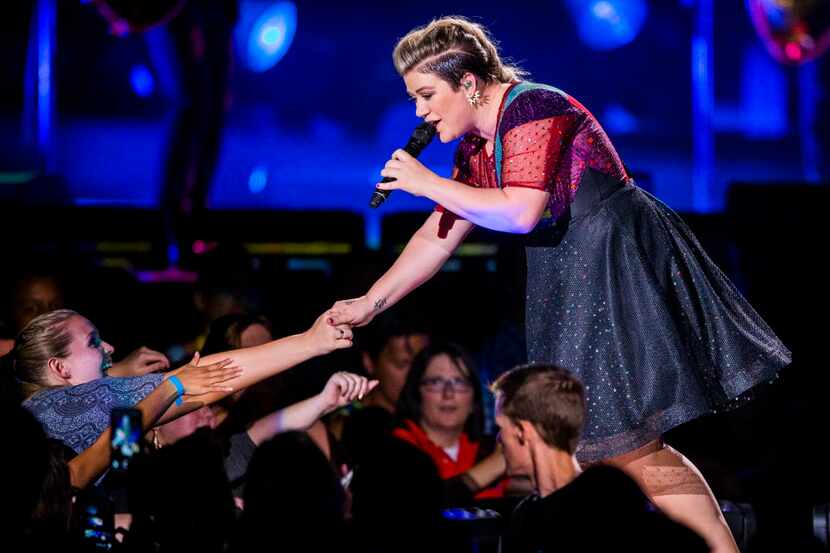 Kelly Clarkson connects with a fan on Sunday, August 30, 2015 at Gexa Energy Pavilion in...