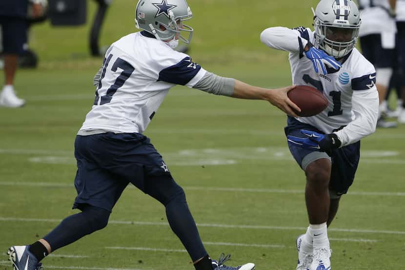 Dallas Cowboys quarterback Kellen Moore (17) hands the ball off to running back Ezekiel...