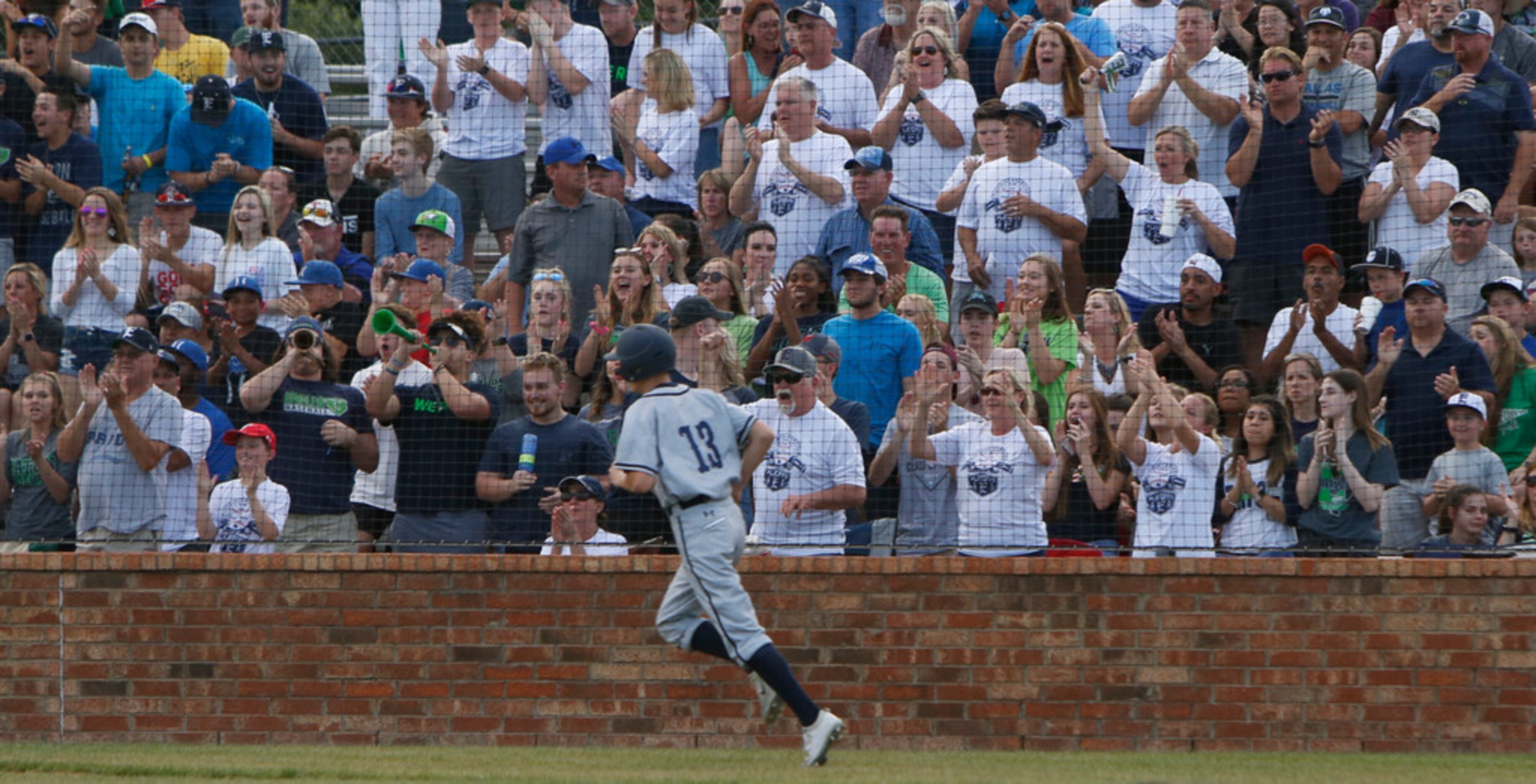 Northwest Eaton's Kolton Graham (13) dashes past the cheer of the fans after scoring in the...