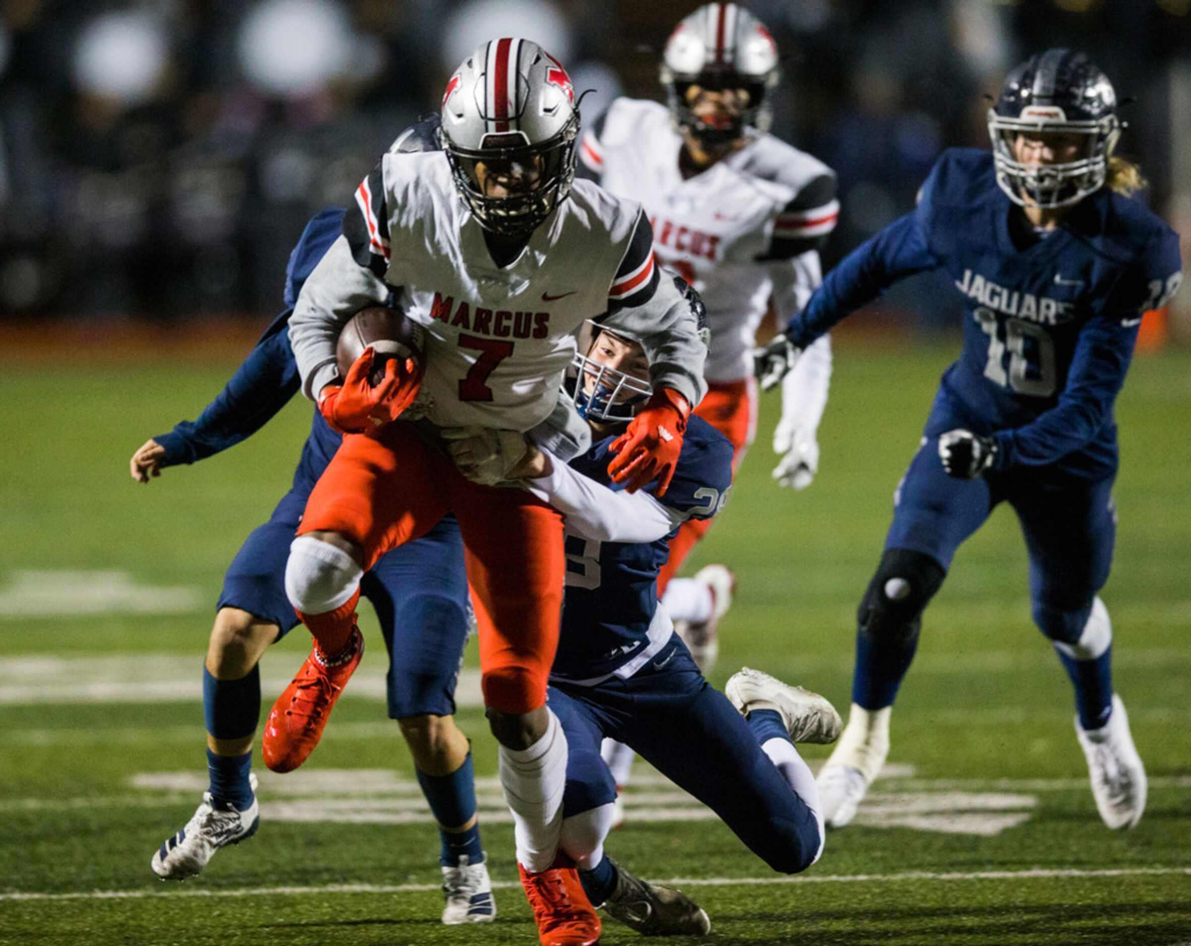 Flower Mound Marcus wide receiver J. Michael Sturdivant (7) is tackled by Flower Mound...