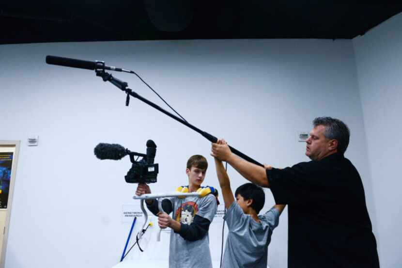 Eric Jewell, production director at The Movie Institute, provides instruction to his son...