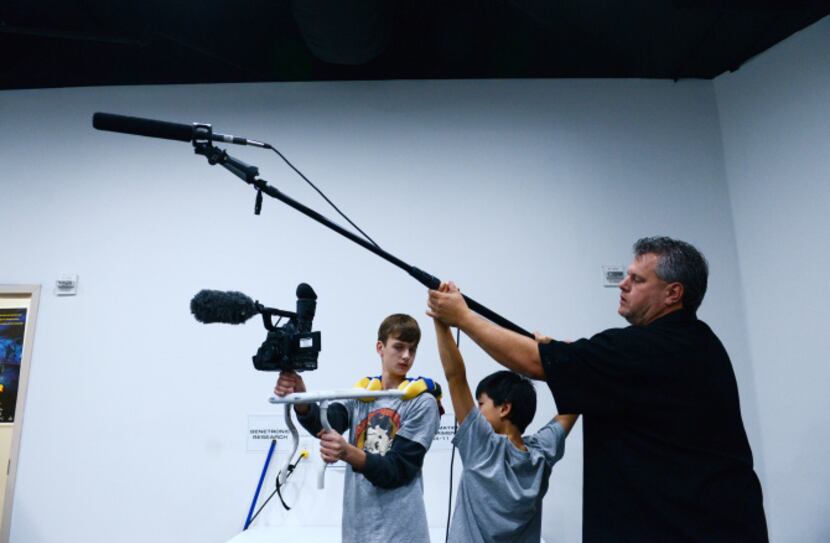 Eric Jewell, production director at The Movie Institute, provides instruction to his son...