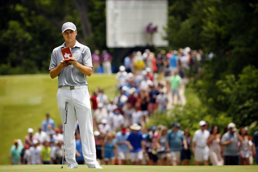 Golfer Jordan Spieth of Dallas, pulls out his notebook as he studies his putt on the par-3,...