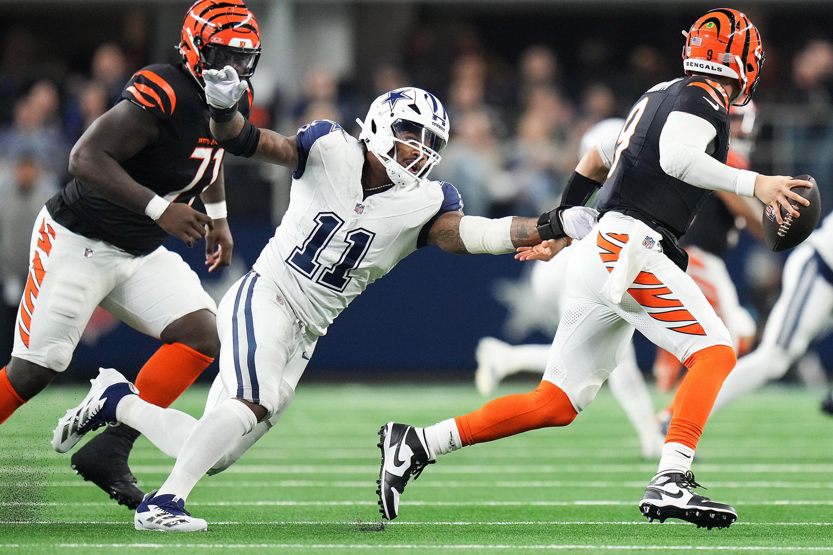 Cincinnati Bengals quarterback Joe Burrow (9) scrambles away from Dallas Cowboys linebacker...