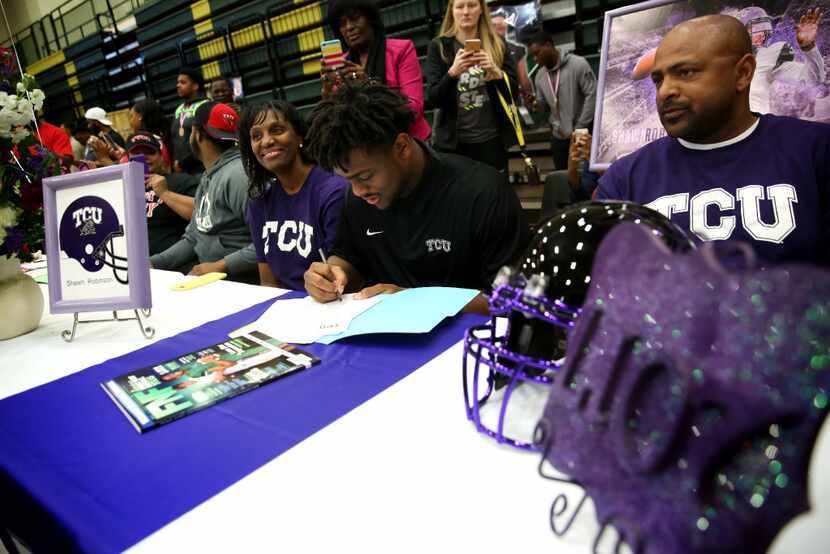Quarterback Shawn Robinson signs with TCU, alongside his parents Andrea and Othell Robinson...