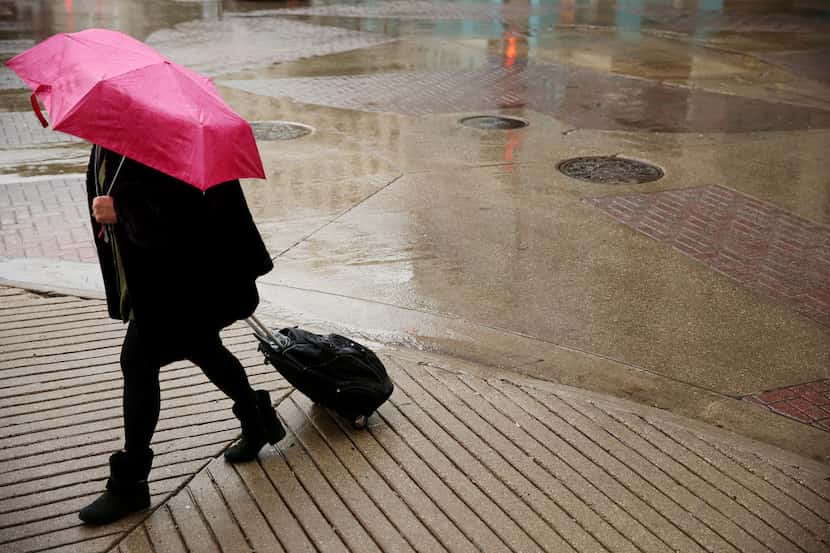 In this Nov. 8 file photo, rain falls on a pedestrian crossing Main and South St. Paul...
