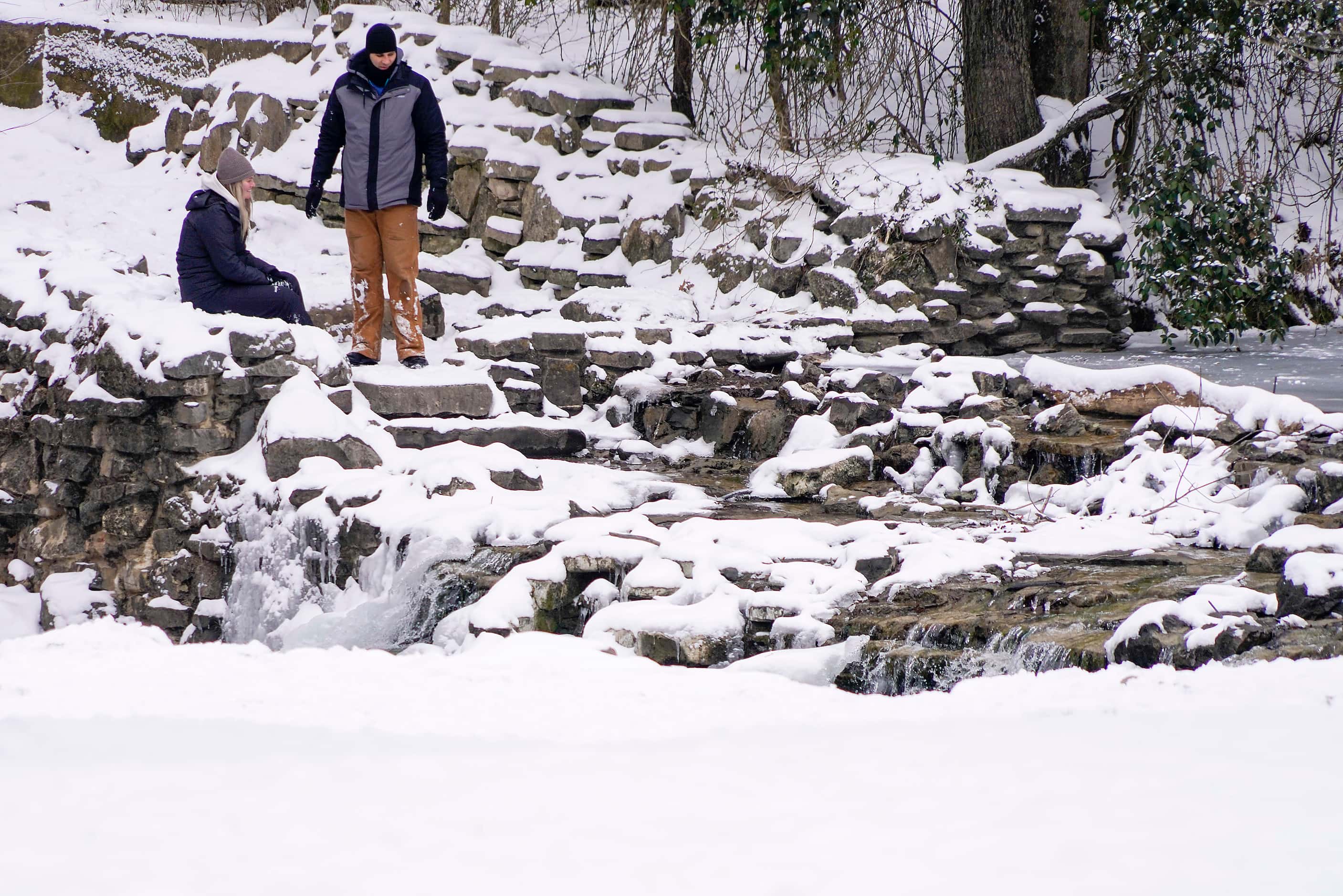 People check out the partially frozen waterfall in Prairie Creek Park after a second winter...