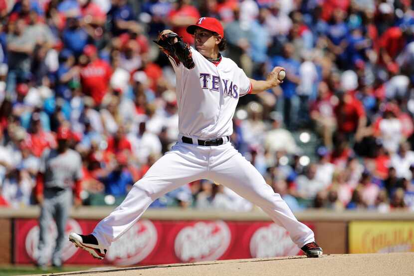 Texas Rangers' Derek Holland delivers to the Los Angeles Angels in the first inning of a...