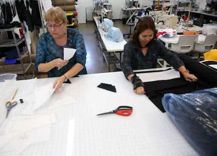 Merri Lester (left), product development engineer, and Ha Vo, sample maker, cut patterns for...