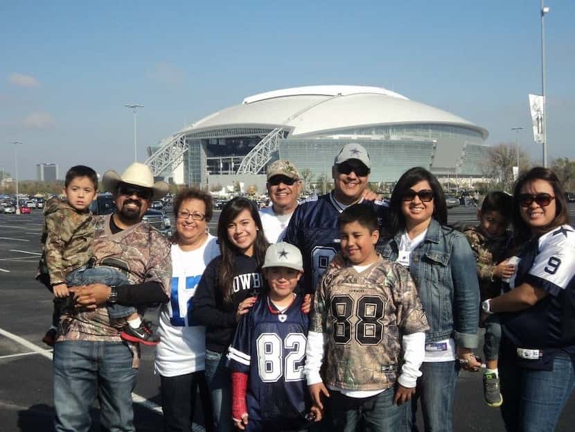 Longtime Cowboys fan Victor Alvarado poses with his family in front of AT&T Stadium in 2011....