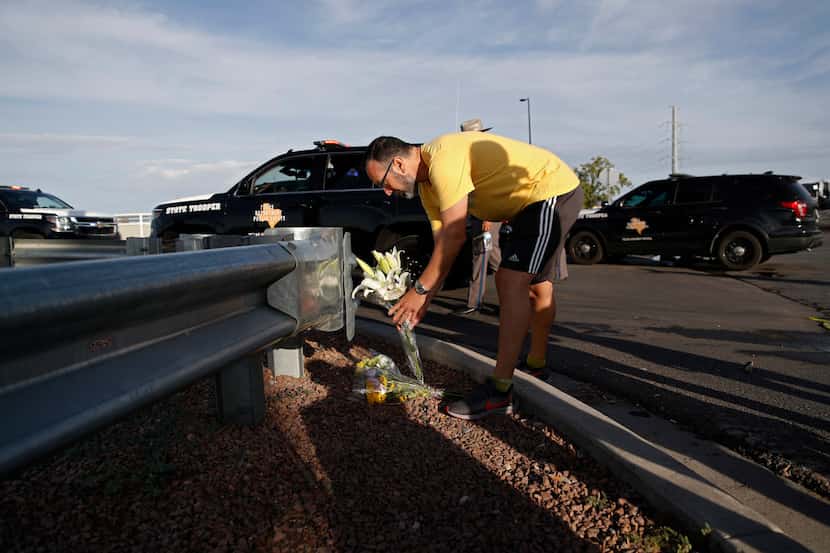 A man leaves flowers near the scene of a mass shooting at a shopping complex Sunday, Aug. 4,...
