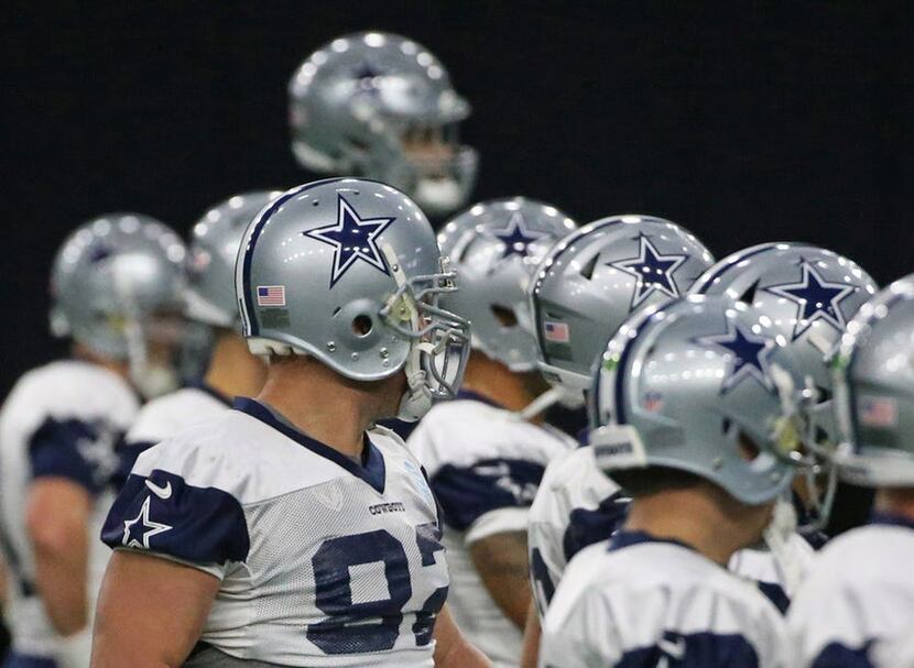 FILE - Dallas Cowboys players line up for stretching exercises before an indoor practice at...
