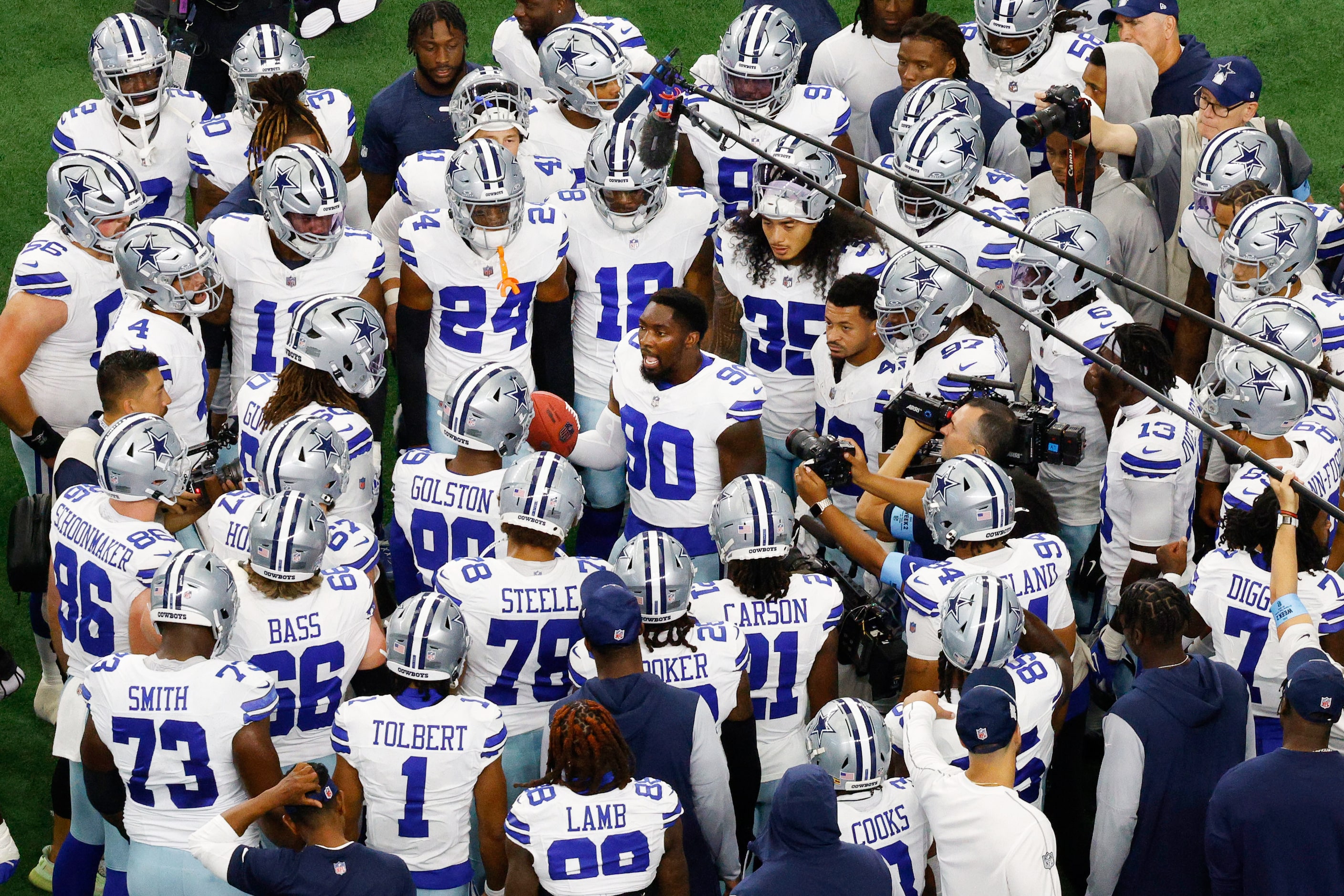 Dallas Cowboys players gather around defensive end DeMarcus Lawrence (90) before an NFL...