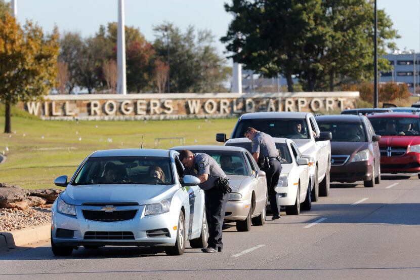 Oklahoma City police officers gather information from vehicles leaving Will Rogers World...