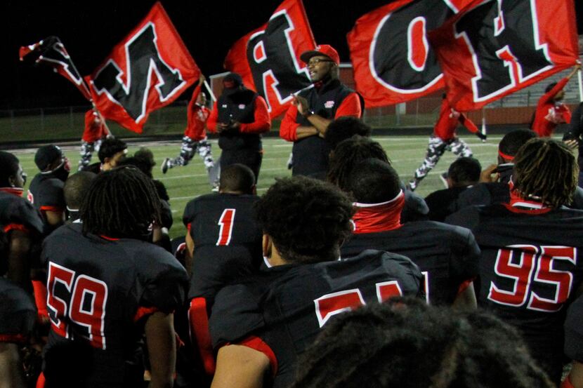 Cedar Hill head coach Carlos Lynn shares a congratulatory message to his team as members of...