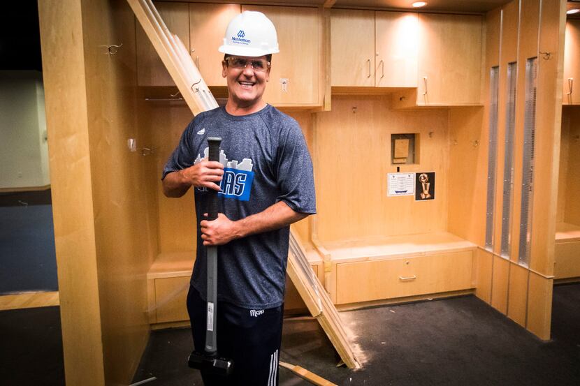 Dallas Mavericks owner Mark Cuban poses with a sledgehammer takes after he began the...