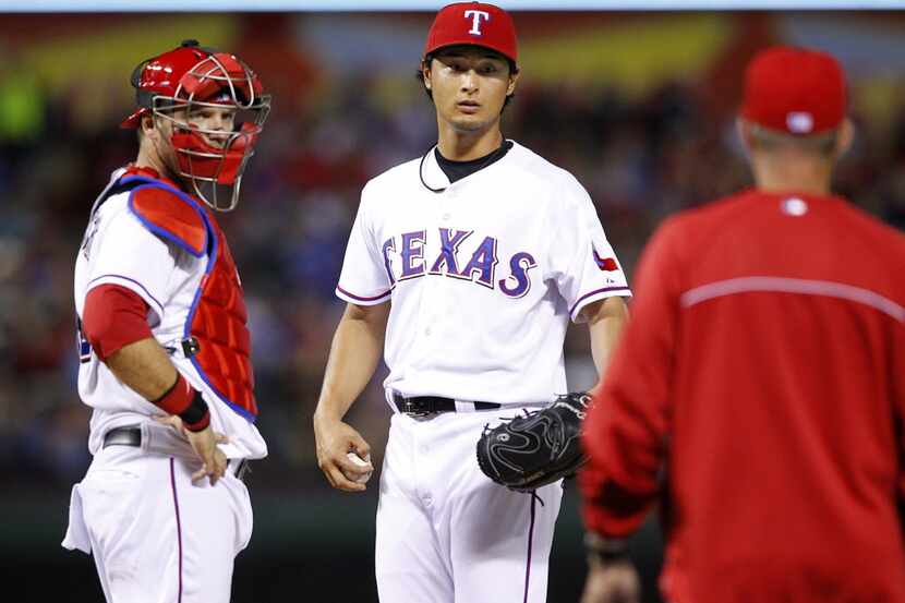 Texas Rangers pitching coach Mike Maddux (31) makes a visit to the mound to speak with...