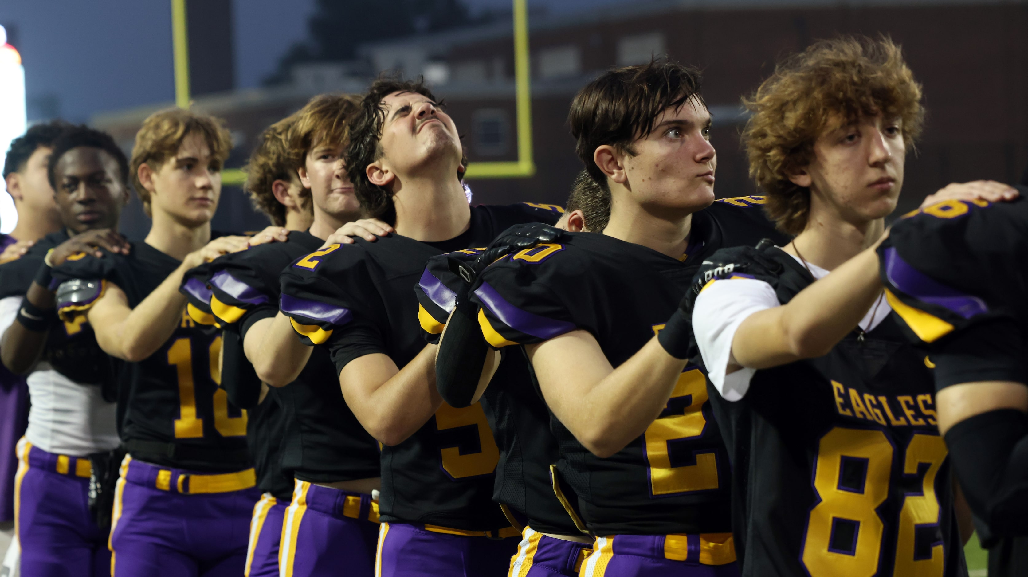 Richardson players pause on the team sidelines for the playing of the national anthem before...