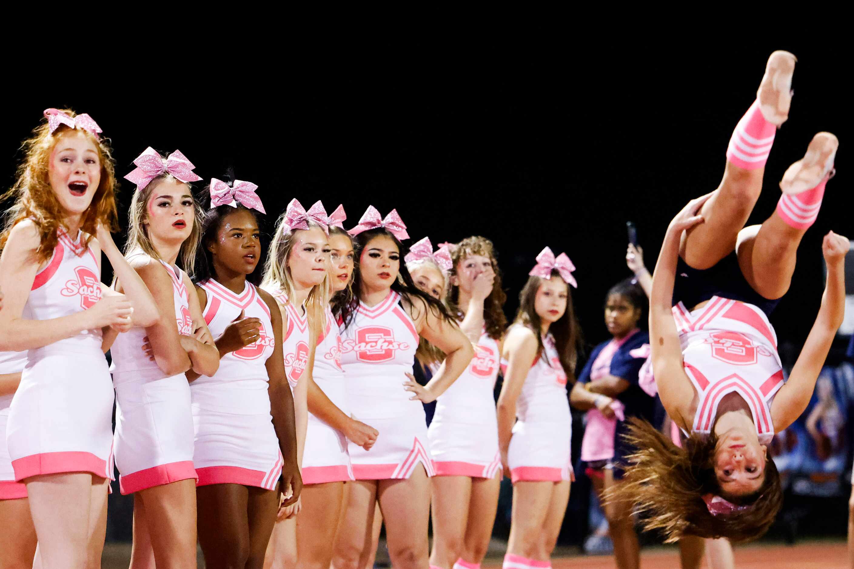 Sachse high school cheerleaders perform during the first half of a football game against...