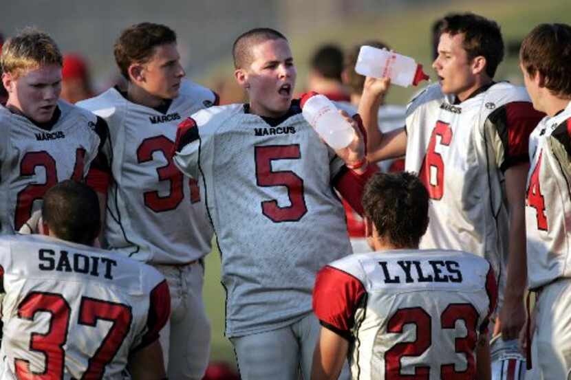Flower MoundMarcus High player Frank Jones (5) takes a water break with teammates during a...