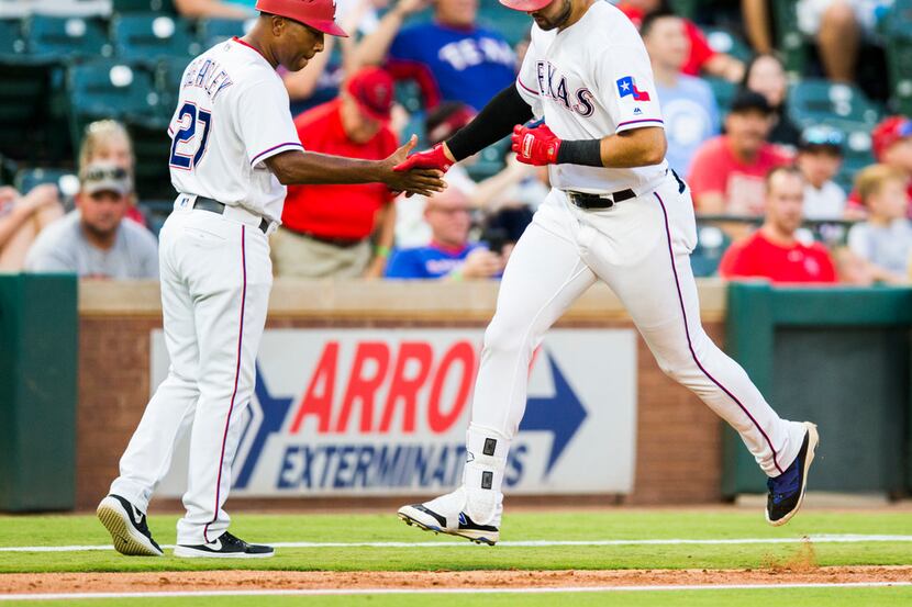 Texas Rangers out fielder Joey Gallo (13) gets a high-five from third base coach Tony...
