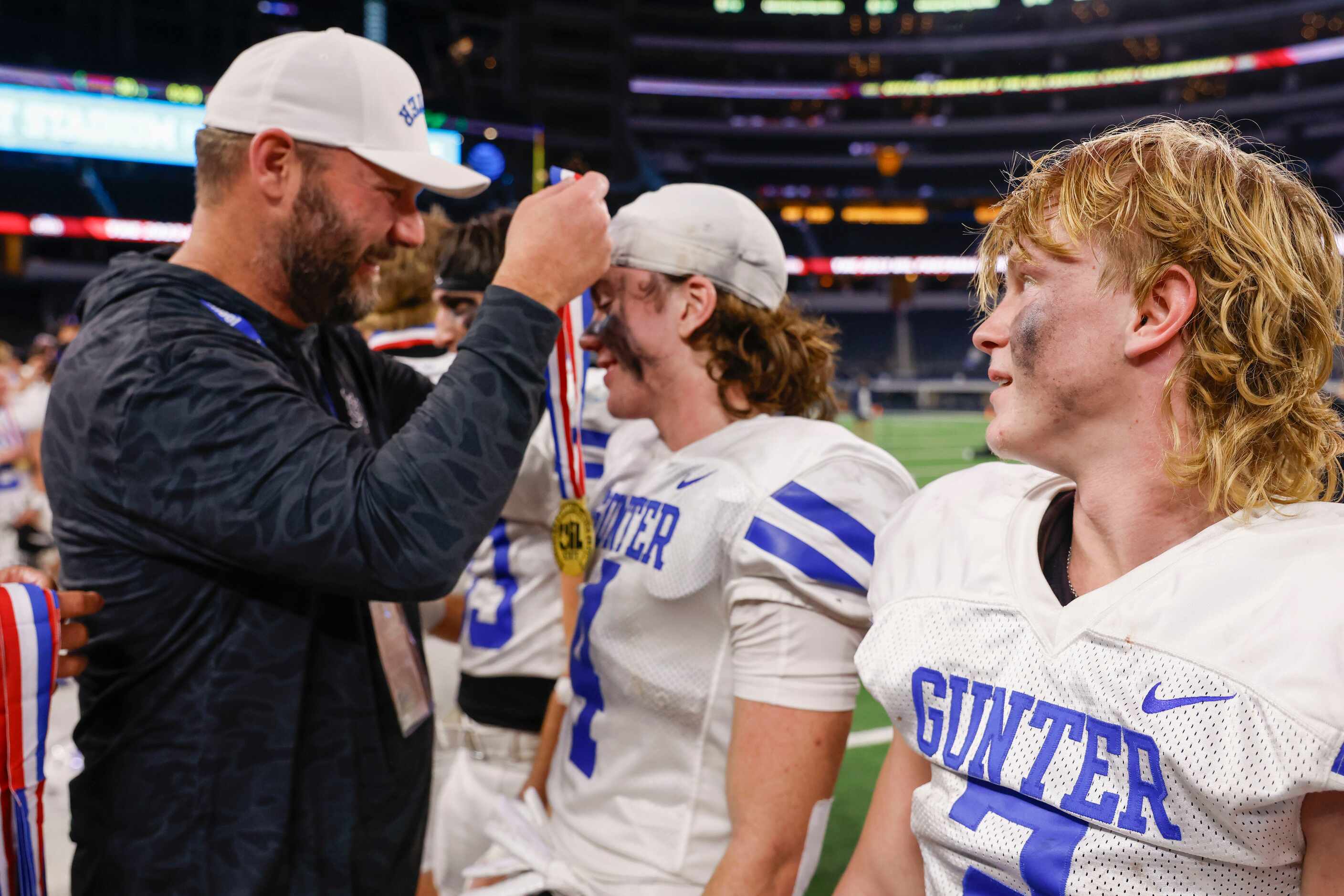 Gunter High’s QB Walker Overman (right) watches as his teammate Jace Martin receives the...