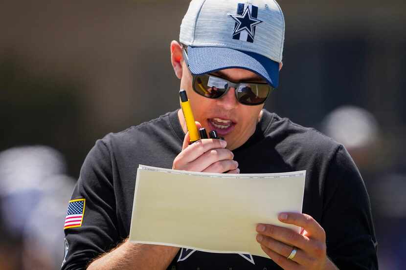 Dallas Cowboys offensive coordinator Kellen Moore talks on a radio during a practice at...