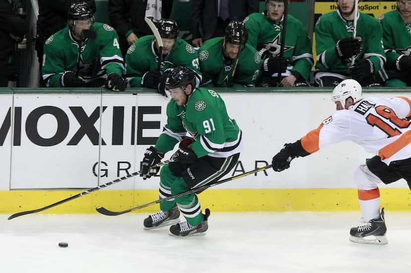 Dallas Stars center Tyler Seguin (91) collects the puck in front of Philadelphia Flyers...