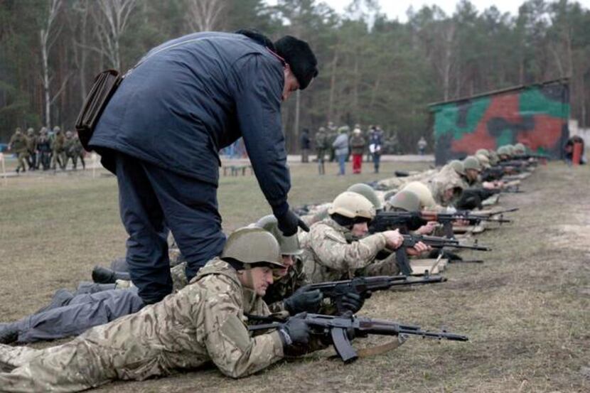 
A Ukrainian interim forces officer supervises recruits during a shooting exercise not far...