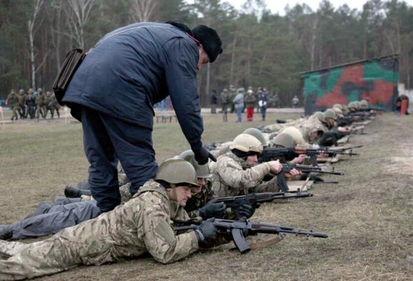 
A Ukrainian interim forces officer supervises recruits during a shooting exercise not far...