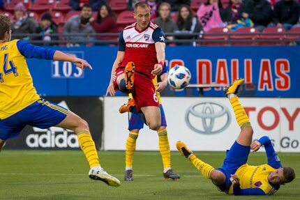 FC Dallas defender Anton Nedyalkov (6) shoots over fallen Colorado Rapids defender Deklan...