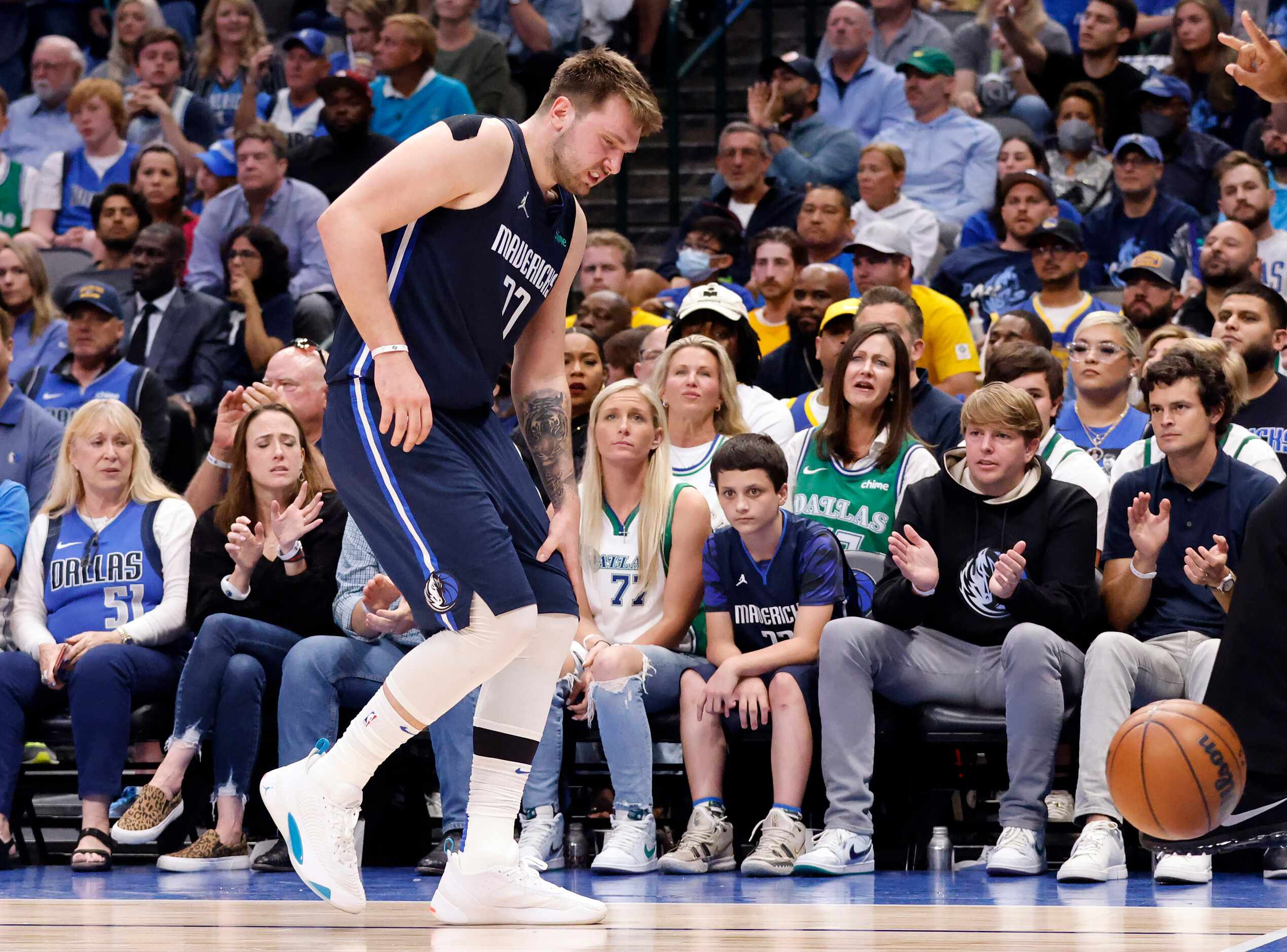 Dallas Mavericks guard Luka Doncic (77) holds his knee after a first half play in Game 3 of...