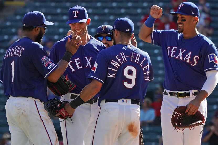 Teammates congratulate Texas Rangers starting pitcher Mike Minor, second from left, on the...
