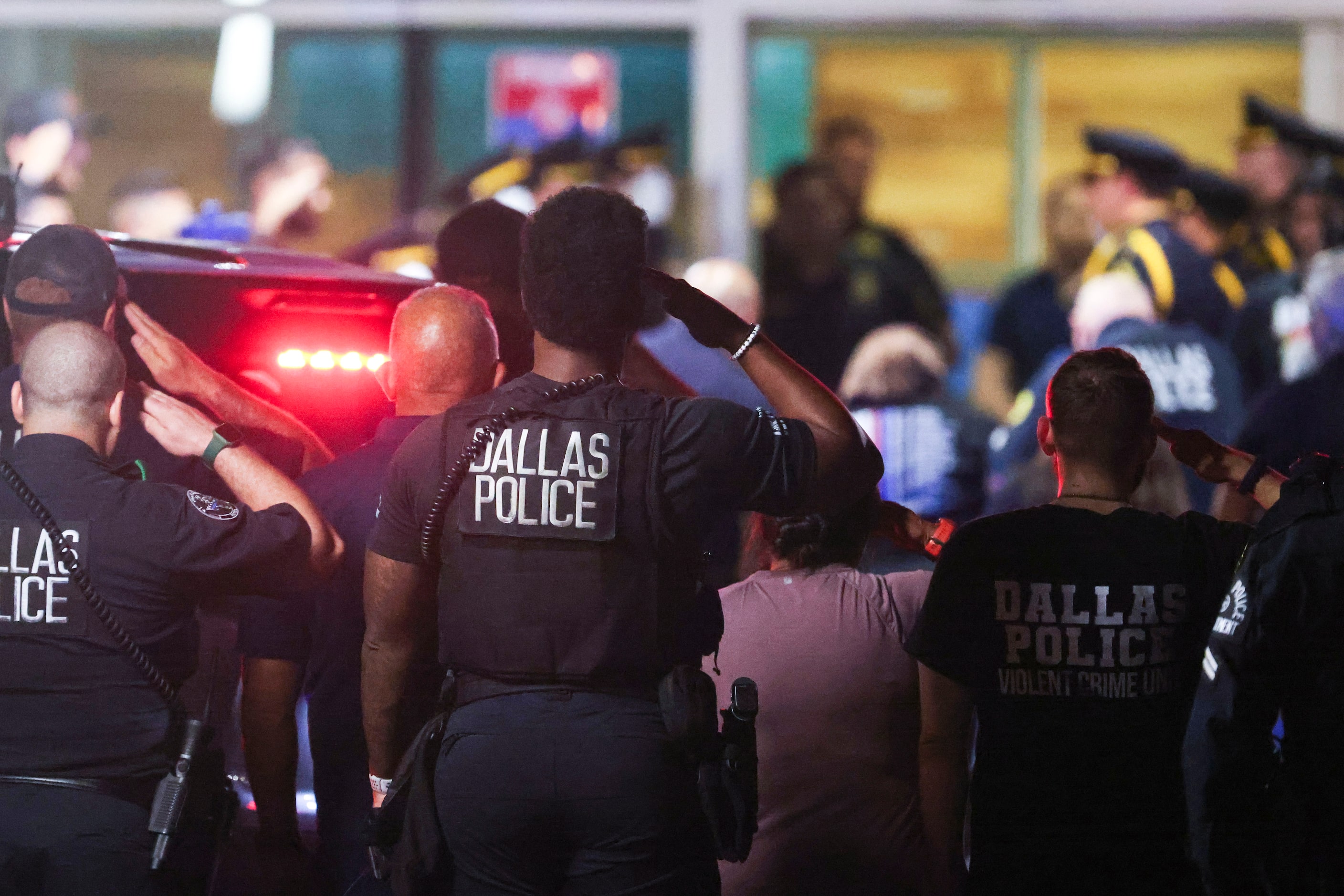 Dallas Police Department officers salutes as family members of the deceased Dallas police...