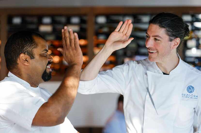 Chef Junior Borges of Meridian, left, high-fives chef Stefano Secchi of the Michelin-star...