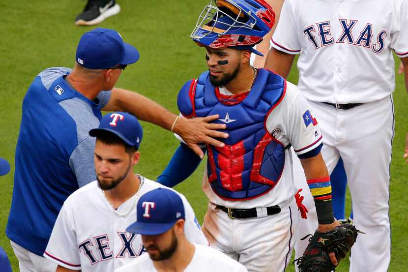 Texas Rangers catcher Robinson Chirinos (61) is congratulated by manager Jeff Banister...