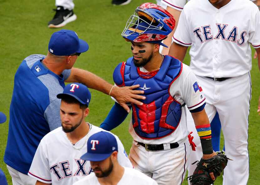 Texas Rangers catcher Robinson Chirinos (61) is congratulated by manager Jeff Banister...