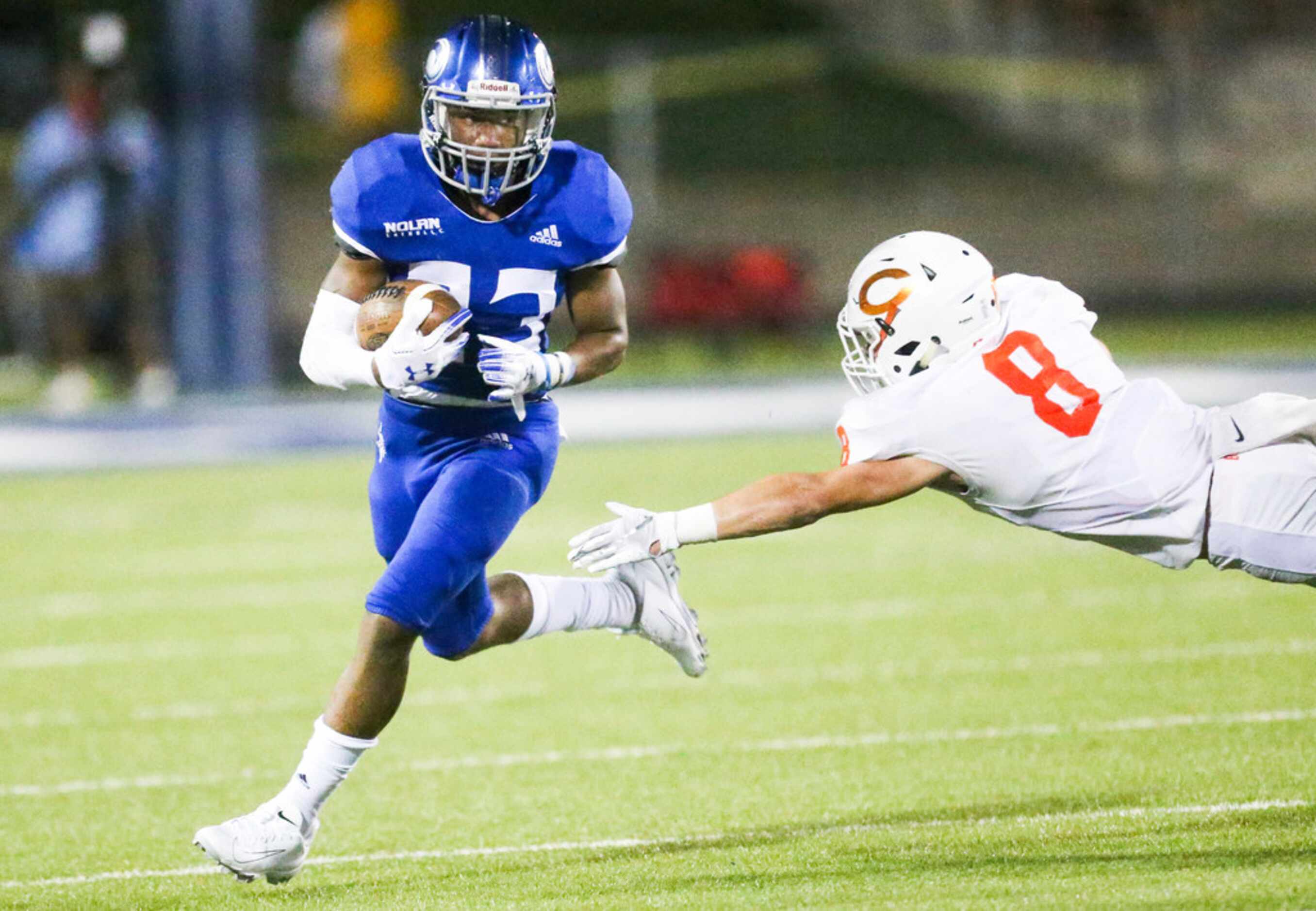 Nolan Catholic running back Sergio Snider (23) carries the ball past Cason Wright (8) during...